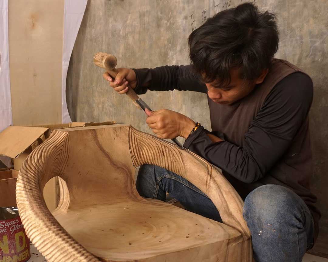 Craftsman carving a large wooden form