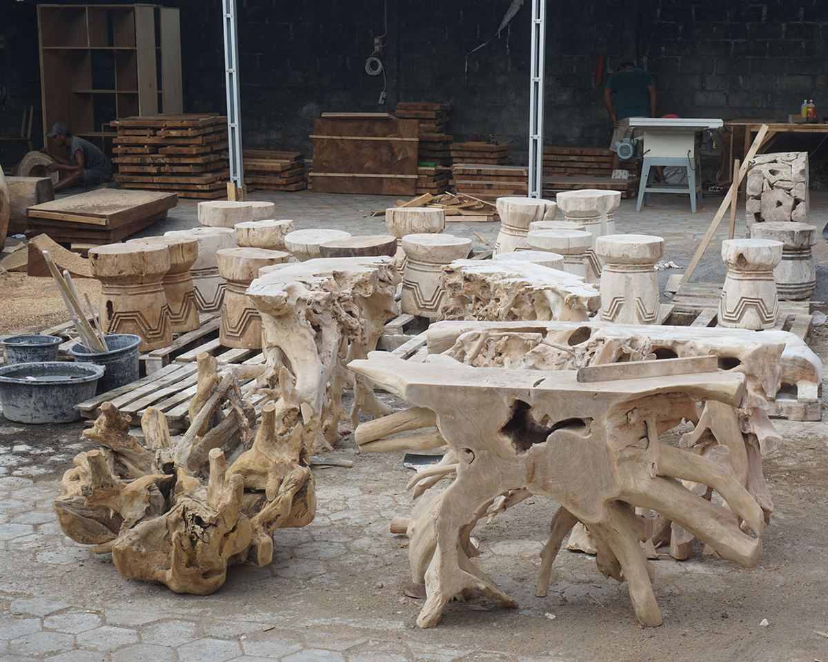Teak root tables and stools in the workshop yard